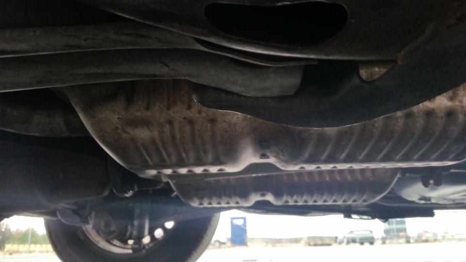 Undercarriage view of a vehicle showing exhaust and suspension components