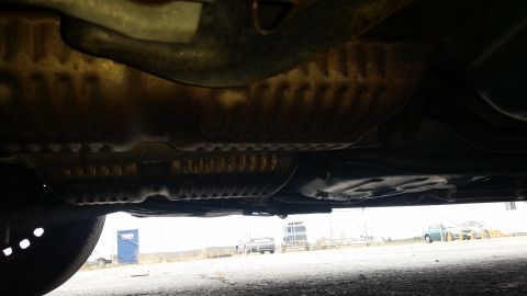 1991 Ford LTD Crown Victoria - View of the undercarriage of a vehicle, with other cars in the distance.