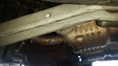 1991 Ford LTD Crown Victoria - Underside view of the exhaust system and frame, showing rusted components.