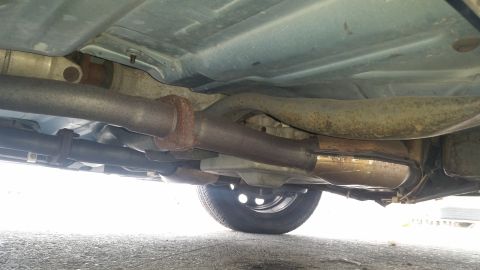 1991 Ford LTD Crown Victoria - The undercarriage of a vehicle, the exhaust system and a rear wheel.