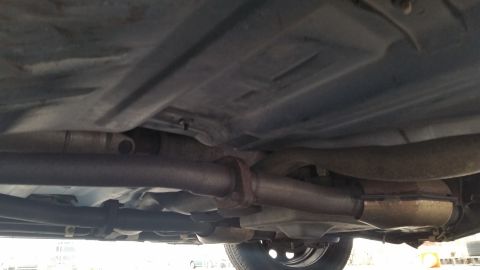 1991 Ford LTD Crown Victoria - Underside view of a car's exhaust system, including pipes and a catalytic converter.