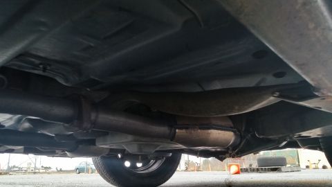 1991 Ford LTD Crown Victoria - The undercarriage of a vehicle, revealing the exhaust system and a wheel.