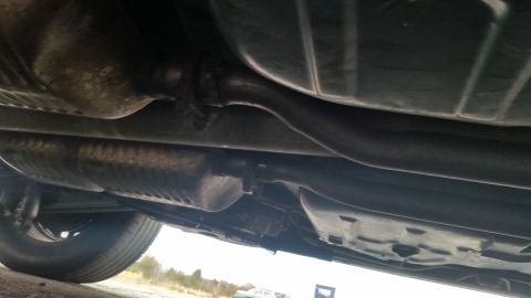 1991 Ford LTD Crown Victoria - The underside of a vehicle is visible, including the exhaust system and a tire.