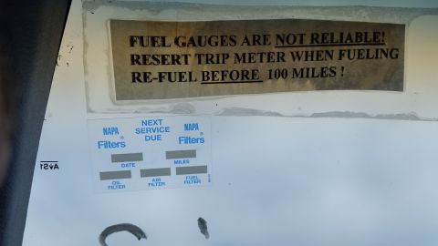 1991 Ford LTD Crown Victoria - Photograph of a fuel-gauge warning sticker and NAPA service-due label on a vehicle surface, not a classifiable technical document.