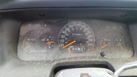 1991 Ford LTD Crown Victoria - The dusty dashboard displays the odometer reading and fuel gauge, indicating the vehicle's interior.