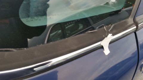 1991 Ford LTD Crown Victoria - Close-up of damaged black trim on a blue car door with a chrome accent.