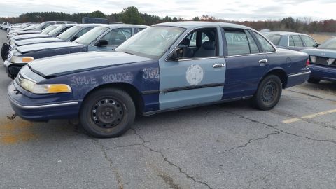 1991 Ford LTD Crown Victoria - A two-tone blue and gray 1991 Ford Crown Victoria LTD police car is parked in a lot with other vehicles.