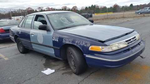 1991 Ford LTD Crown Victoria - A former state police car sits in a lot, showing its two-tone paint scheme and police markings.