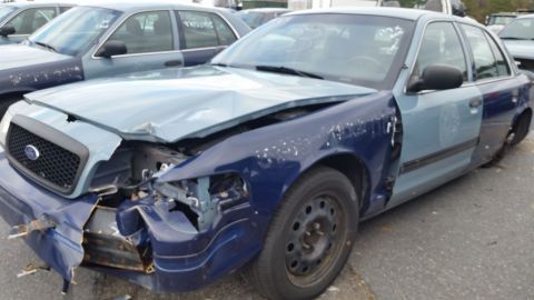 1991 Ford LTD Crown Victoria - This heavily damaged 1991 Ford Crown Victoria LTD shows significant front-end collision impact and mismatched body panels.