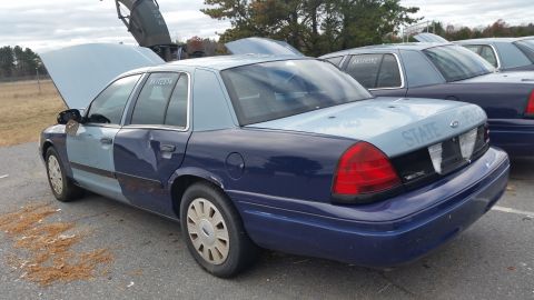 1991 Ford LTD Crown Victoria - Two-tone Ford Crown Victoria police car parked outdoors with other similar vehicles.