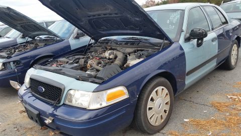 1991 Ford LTD Crown Victoria - Two-tone Ford Crown Victoria sedan with hood open, parked in a lot with other similar vehicles.