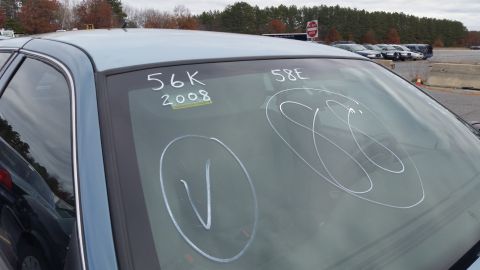 1991 Ford LTD Crown Victoria - Chalk markings on a blue sedan's windshield include '56K 2008' and '58E', with other circled notations.
