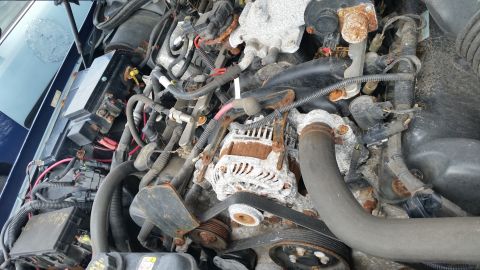 1991 Ford LTD Crown Victoria - The engine bay of a 1991 Ford Crown Victoria LTD shows extensive rust and corrosion on the alternator and surrounding parts.