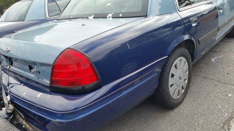 1991 Ford LTD Crown Victoria - Rear view of a two-tone police car, with visible 'POLICE' text on the trunk lid.