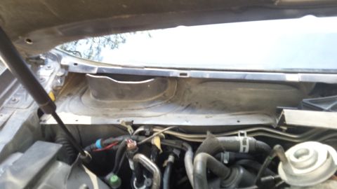 1998 Lincoln Mark VIII - The cowl area of the engine bay shows hoses, wiring, and the base of the windshield.