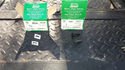 1998 Lincoln Mark VIII - Boxes of automotive fasteners, including grille grommets and trim screws, are laid out on a textured metal surface.