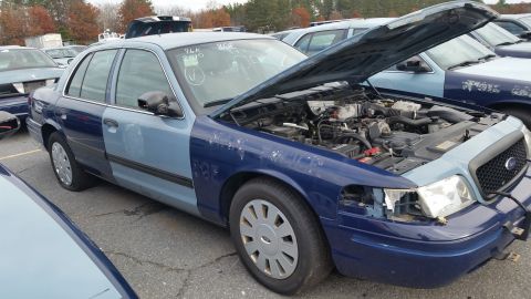 1991 Ford LTD Crown Victoria - This Ford Crown Victoria has a two-tone paint job and its hood is open, revealing the engine compartment.