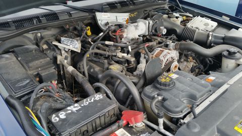 1991 Ford LTD Crown Victoria - The engine bay of a Ford Crown Victoria displays its V8 engine and various components, including a coolant reservoir and a fuse box with ma…