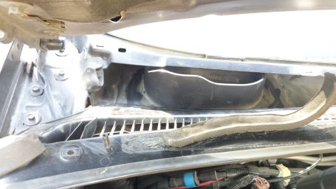 1998 Lincoln Mark VIII - The windshield cowl area shows a black plastic housing and a foam seal, with visible wiring below.