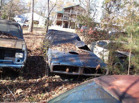 1974 Dodge Challenger - Junkyard scene with multiple abandoned muscle cars, including a blue one with a damaged hood.