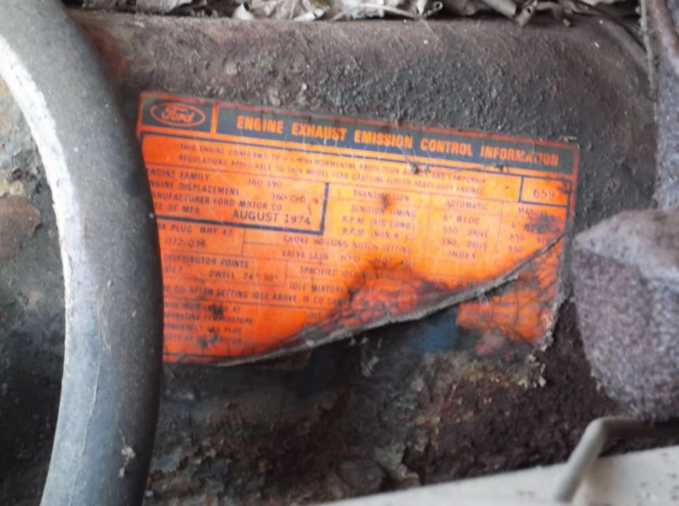Orange Ford engine emission control sticker with "AUGUST 1974" visible