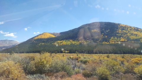 1996 Ford Bronco - A scenic view of a mountain during autumn, with a mix of evergreen and deciduous trees displaying fall colors.