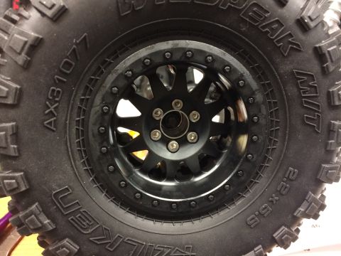 1989 Ford Bronco - Close-up of a black off-road tire and wheel assembly, showing tire brand and size markings.