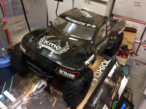 1989 Ford Bronco - A black remote control monster truck with KMC Wheels decals sits on a box.