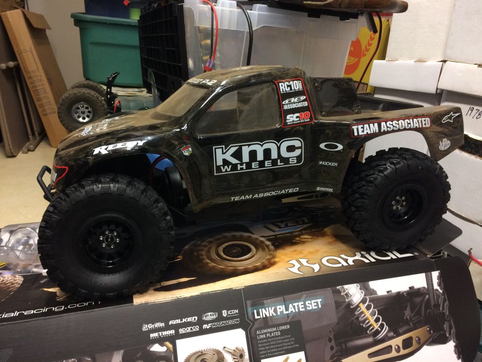 Black RC10 Team Associated truck with KMC Wheels decals, sitting on a box