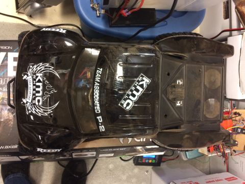 1989 Ford Bronco - A black remote control car with KMC Wheels and Team Associated P-2 branding sits on a box.