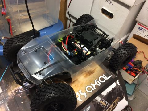 1989 Ford Bronco - RC crawler chassis with clear body and internal components, sitting on an Axial box.