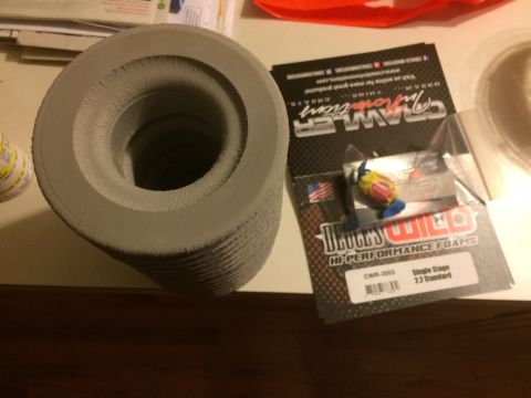 1989 Ford Bronco - Foam tire inserts and packaging for RC car parts are displayed on a table.