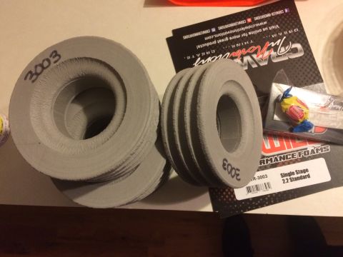 1989 Ford Bronco - Stack of gray rings, some with handwritten numbers, sit beside product packaging for 'Crazy Innovations' and 'Performance Foams'.