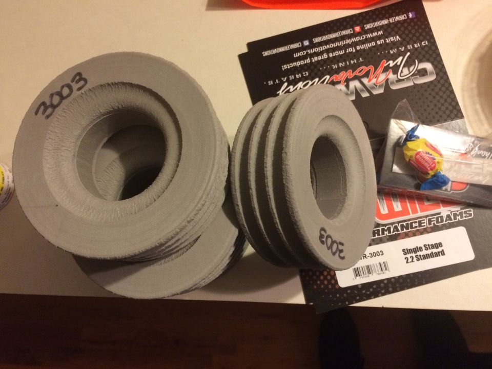 Gray rings with '3003' and 'E00E' handwritten, next to 'CRAZY INNOVATIONS' and 'PERFORMANCE FOAMS' packaging