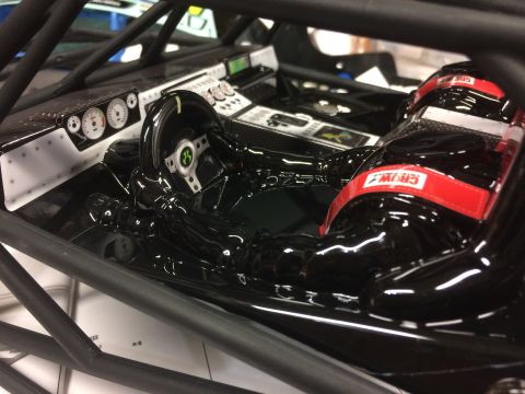 1989 Ford Bronco - Interior view of a black racing vehicle with a roll cage and detailed dashboard.