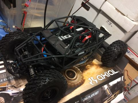 1989 Ford Bronco - A black remote control rock crawler sits on a box, its detailed interior and tires.