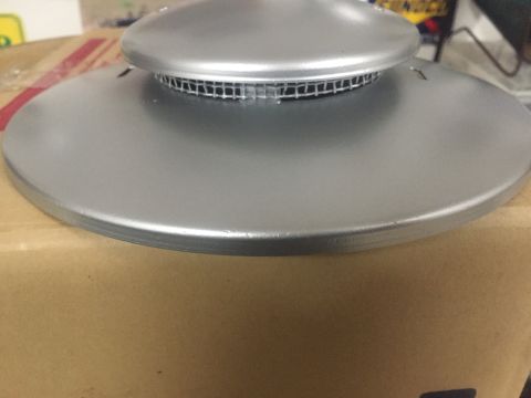 2014 Dodge 1500 - A silver hubcap with a mesh vent is shown close-up, placed on a cardboard box.