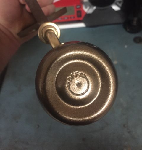 2014 Dodge 1500 - A brass knob with an embossed OFF indicator is held by a hand.