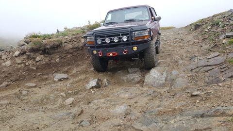 1996 Ford Bronco - This 1996 Ford Bronco tackles a challenging rocky mountain pass, its off-road capabilities with an upgraded bumper and lighting.