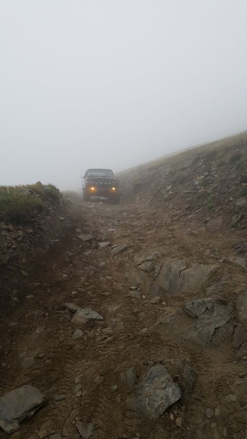 1996 Ford Bronco - Bronco navigating a challenging off-road path shrouded in fog.