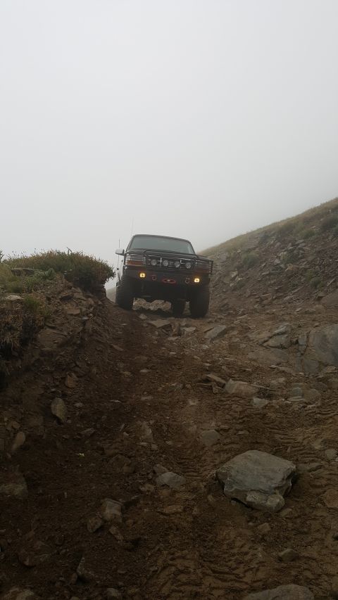 1996 Ford Bronco - A 1996 Ford Bronco navigates a challenging off-road path in foggy conditions.