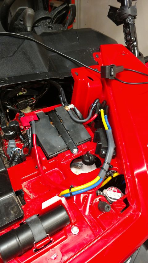 2016 Honda TRX 90 - Close-up of an ATV's battery compartment showing wiring and battery.