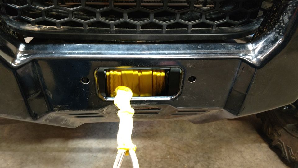 Black bumper with a yellow winch and tow strap