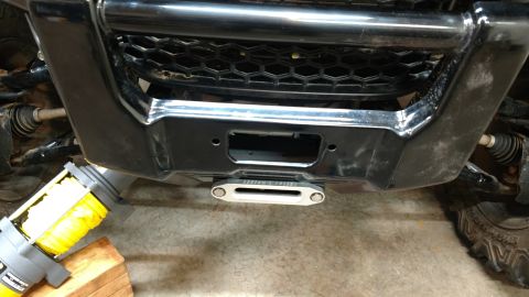 2016 Honda TRX 90 - Close-up view of an ATV's front bumper and winch assembly, with a black grille and metallic accents visible.