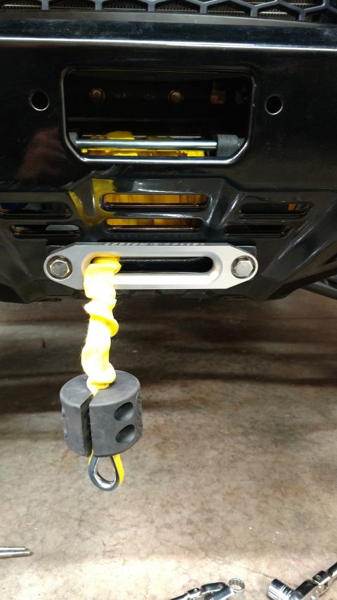 2016 Honda TRX 90 - A winch with a yellow rope and a weight is attached to the front of a vehicle.