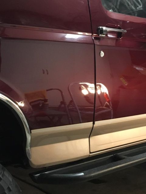 1996 Ford Bronco - Close-up of the side of a 1996 Ford Bronco, showing the door and lower body panel.