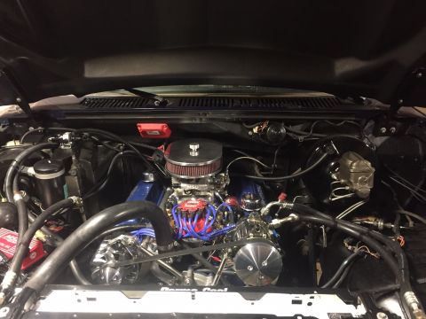 1982 Ford Bronco - The engine bay of a vehicle is shown with various components and wiring, including a prominent V8 engine.