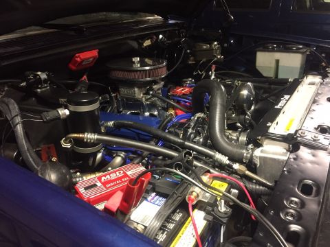 1982 Ford Bronco - Close-up view of a modified engine bay with various aftermarket parts and wiring.