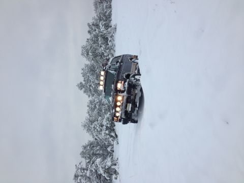 1996 Ford Bronco - 1996 Ford Bronco navigating a snowy road with trees on the side.