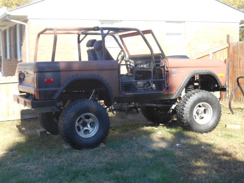 1972 Ford Bronco - This modified Ford Bronco is undergoing restoration with a prominent roll cage and off-road modifications.